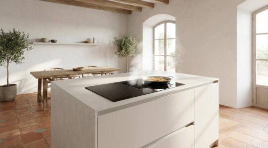 Placa de inducción con extractor integrado en isla de cocina moderna con diseño minimalista